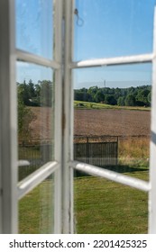 View From Open Window In The Village. White Old Wooden Windows With View On Blue Sky And Green Field. Symbol Of Insouciance, Freedom, Summer Atmosphere. Holiday House, Summer Cottage, Weekend Cottage.