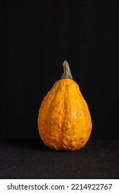 View Of Orange Pumpkin For Halloween On Table With Tablecloth And Black Background, Vertical