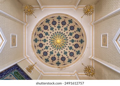 A view of the ornate ceiling inside the Goy Imam Mosque in Ganja, Azerbaijan. The dome is adorned with intricate geometric patterns in shades of blue, green, and gold - Powered by Shutterstock