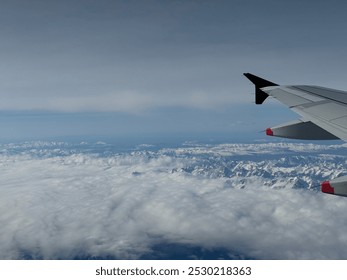 View Out of Airplane of Snow Capped Mountain Range - Powered by Shutterstock