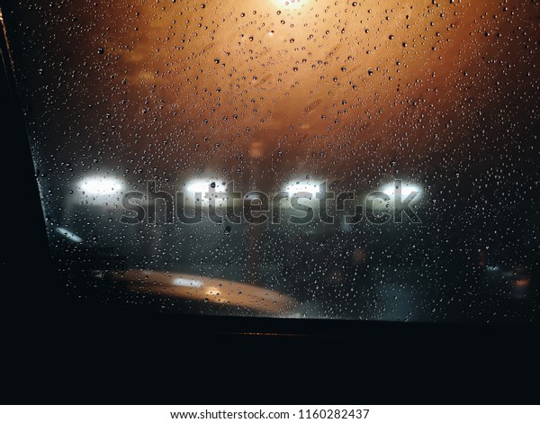 View outside of the window car stop on the road\
during rush hour and traffic jam in the dark night with colorful\
bokeh and blur light.