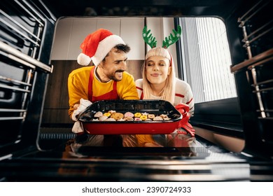 View from the oven of happy couple baking gingerbread cookies on christmas and new year. - Powered by Shutterstock