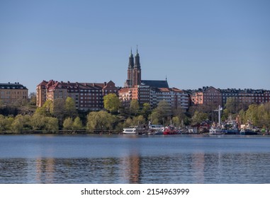 View Over The Bay Riddarfjärden With Churches And Apartment Buildings Over A With Wharfed Boats A Sunny Spring Day In Stockholm