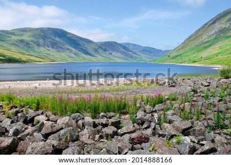 View over beautiful cooling blue water of loch turret reservoir with green Scottish hills above the valley, summer day, Scotland landscape