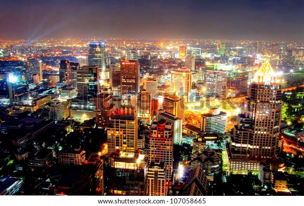 a view over the big asian city of Bangkok , Thailand at nighttime when the tall skyscrapers are illuminated