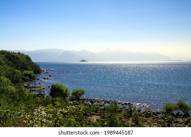 View Over Blue Glittering Lake With Blurred Misty Foggy Mountains In Twilight Of Morning Sun -  Parque Nacional Conguillío, Chile