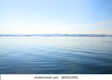 View over the calm ocean looking towards the horizon with pale pastel shades of blue, turquoise & white, off the coast of Stavanger, Rogaland county, Norway. 