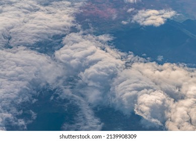 View Over The Clouds Above Tanzania. Bright Skyscape And Green Land Beyond