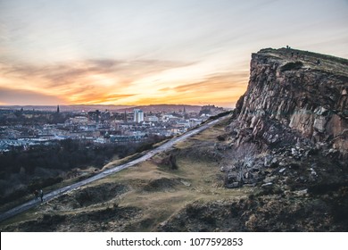 View over Edinburgh cityscape from up Arthur's Seat, at sunset, with orange and yellow tones - Shutterstock ID 1077592853