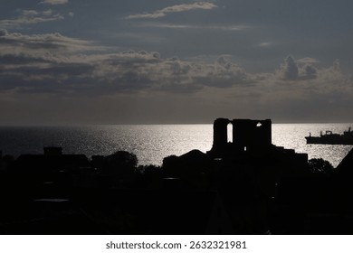 View over Gotland with silhouette ruins in foreground and water in background