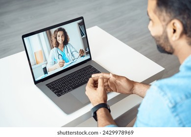 View over male client shoulder sit at desk receive medical consultation online from female doctor. Indian man listening practitioner. Distant communication, health protection and telemedicine concept - Powered by Shutterstock