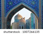View over the mausoleums and domes of the historical cemetery of Shahi Zinda through an arched gate, Samarkand, Uzbekistan.