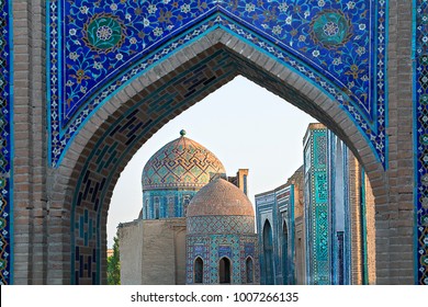 View over the mausoleums and domes of the historical cemetery of Shahi Zinda through an arched gate, Samarkand, Uzbekistan.