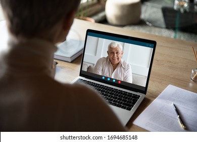 View Over Medical Insurer Shoulder, Consulting Old Client On-line By Videoconference App. Adult Daughter Talks With Mature Dad Who Lives In Country Or Nursing Home. Virtual Meeting Modern Tech Concept