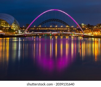 A view over the River Tyne, towards the Gateshead Millennium Bridge and Tyne Bridge in Newcastle upon Tyne, Northumberland, UK.