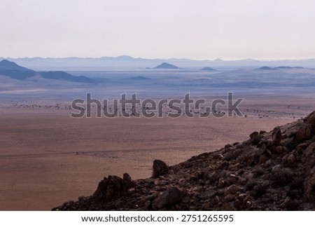 View over the vast and empty plains of the Spergebiet in the Namib Desert with the distant bleu inselbergs,