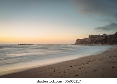 View of the Pacific coast at sunset with a hotel on a cliff. Half Moon Bay, California