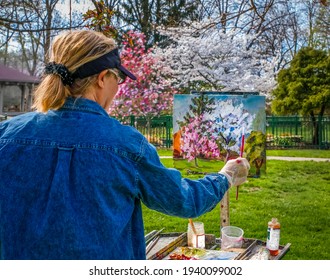 View of painting of blooming trees and bushes in a public garden in the spring by older woman painter; spring in Missouri - Powered by Shutterstock