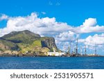 View of the Palermo port and Monte Pellegrino in Sicily Italy. Boats float on calm water with a majestic mountain rising in the background