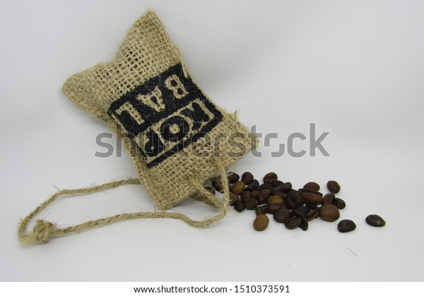 View of parfum kopi bali or Car air freshener\
and room perfume with authentic Bali coffee beans. Fragrance\
hanging rope. Packaging small jute sack cubes karung goni. Isolated\
on white background
