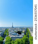 View of Paris from the Arc de Triomphe. With the Eiffel Tower, trees, blue sky, historic buildings and streets.