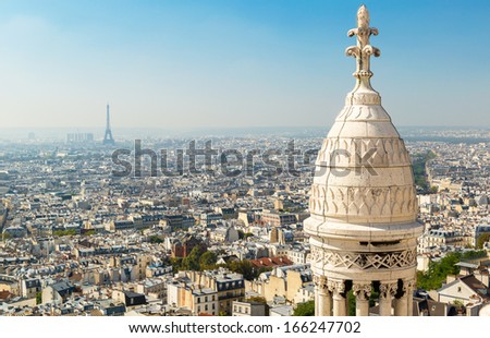 View of Paris from Sacre Coeur on Montmartre hill, France. Sunny Paris skyline background. Panorama of Paris, Eiffel tower in distance. Basilica of Sacre Coeur (Sacred Heart) is landmark of city.