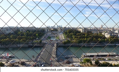 View of Paris from top of the Eiffel Tower through fence