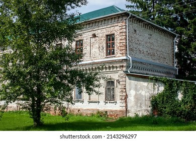 View Of A Part Of An Old House In Summer. Corner Of An Old Brick House On A Sunny Summer Day. Green Trees In Front Of A Brick House.