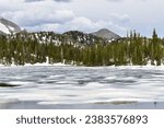 View of the partially frozen Lake Marie and the Medicine Bow-Routt mountains from the shoreline