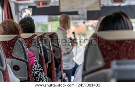 View of the passengers inside a stage coach bus. Bus interior trip. Transport, tourism, road trip and people concept. Bus interior showing passengers during a trip, highlighting tourism, road journey, and group travel.