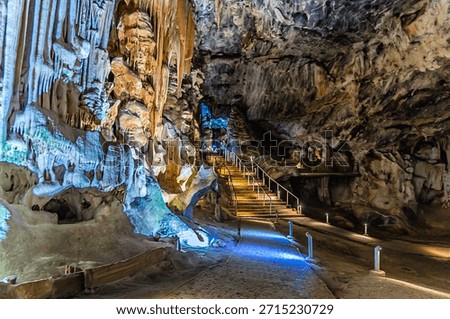 A view past limestone structures towards steps in a large chamber in Cango Caves, South Africa in springtime