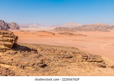 A view past rocky outcrops in the vast desert landscape in Wadi Rum, Jordan in summertime