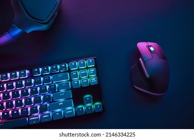 View of pastel neon color backlighted computer keyboard and mouse from above. Professional computer game playing, esport business and online world concept. - Shutterstock ID 2146334225