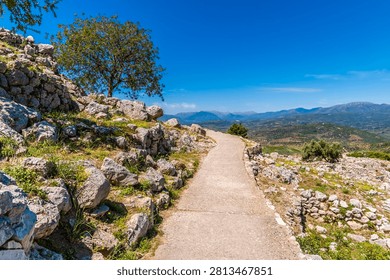 A view up a path leading to the upper level of the ruins of the archaeological site of Mycenae in Greece in early summertime