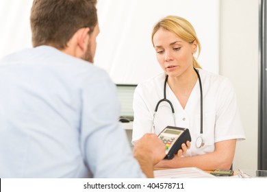 View Of A Patient Paying The Doctor By Credit Card