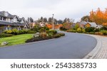 View of a peaceful residential street in Victoria, Vancouver Island, showcasing charming homes and vibrant autumn foliage. This serene neighborhood scene captures a tranquil