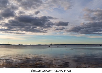 View of Penobscot Bay in Maine with boats moored in the distance in the early morning light.