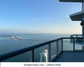 View From Penthouse Balcony Atop Miami High Rise Building Looking Towards Biscayne Bay Bridge And Key Biscayne.