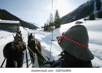 View Of A Person In A Horse Drawn Carriage Traveling On Snow Covered Ground, Dischmatal, Davos, Graubuenden, Switzerland