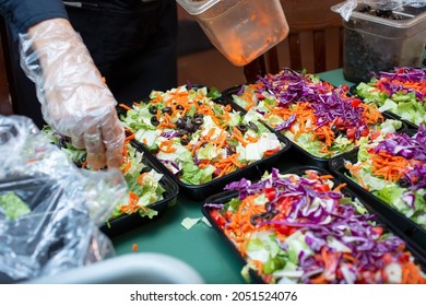 A View Of A Person Preparing Salad Meal Prep Containers.