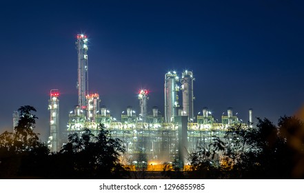 View Of Petrochemical And Petroleum Plant Industry With Refinery Stack And Tank Farm In In Chemical Industrial Zone At Night After Sunset