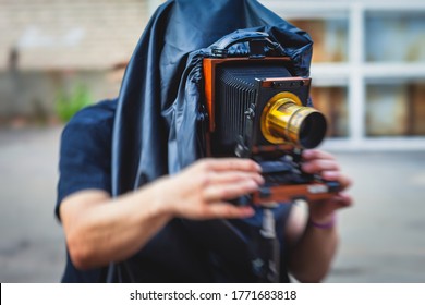 View of a photographer with an old-style vintage retro camera, old fashioned photo camera, man shooting photography in old style
