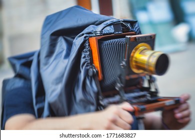View of a photographer with an old-style vintage retro camera, old fashioned photo camera, man shooting photography in old style