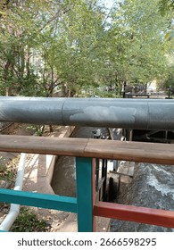 View of a pipe over a river with trees in the background