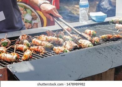 A View Of A Pit Master Cooking Bacon Wrapped Jalapeño Poppers On The Grill.