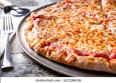 A View Of A Plain Cheese Pizza Pie, In A Restaurant Or Kitchen Setting.