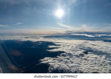 view from the plane over mountains and clouds