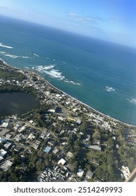 View from plane over ocean with clouds and water sun setting and night fall over the city 
