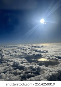 View from plane over ocean with clouds and water sun setting and night fall over the city 