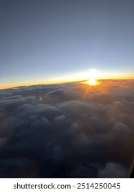 View from plane over ocean with clouds and water sun setting and night fall over the city 